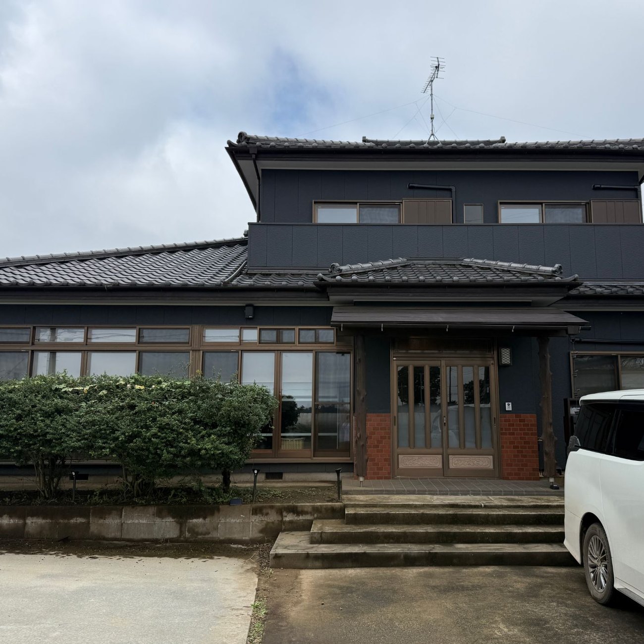 改修後の本社。黒い外壁と玄関のレンガ