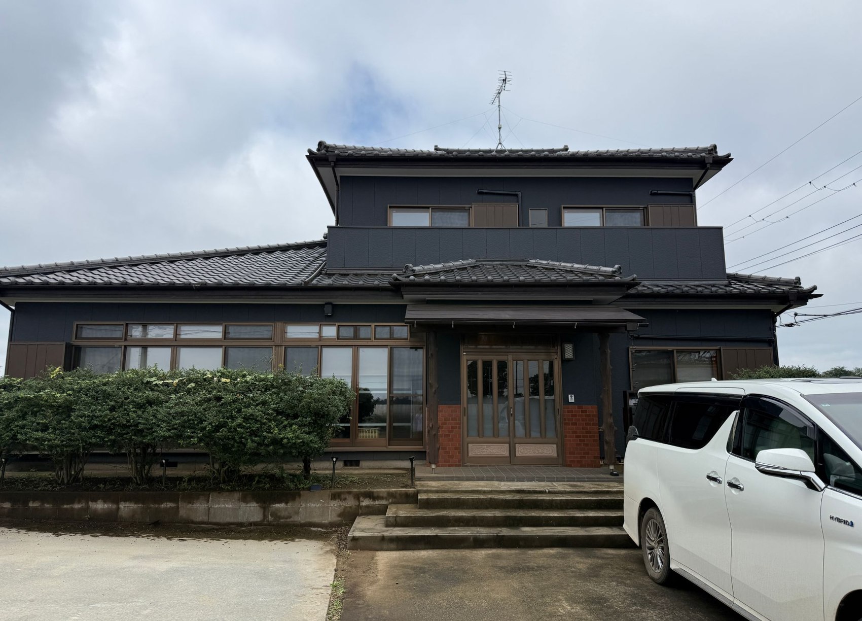 改修後の本社。全景。黒い外壁と玄関のレンガ
