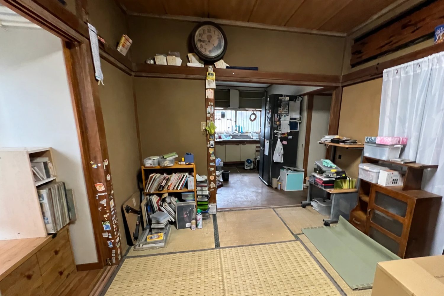 改修前の和室。畳と荷物、奥に台所